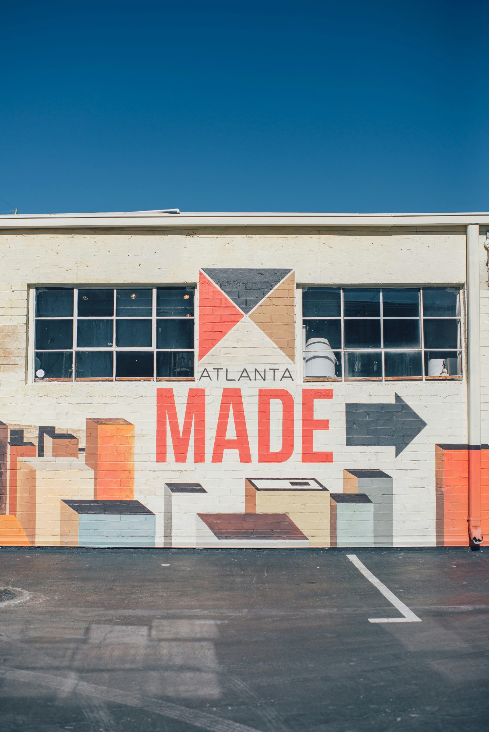 A colorful mural of skyscrapers and words "Atlanta Made" on the side of a warehouse