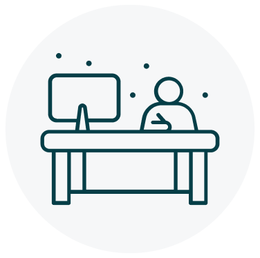 A navy blue person sitting at a desk with a computer icon on a circular light grey background.